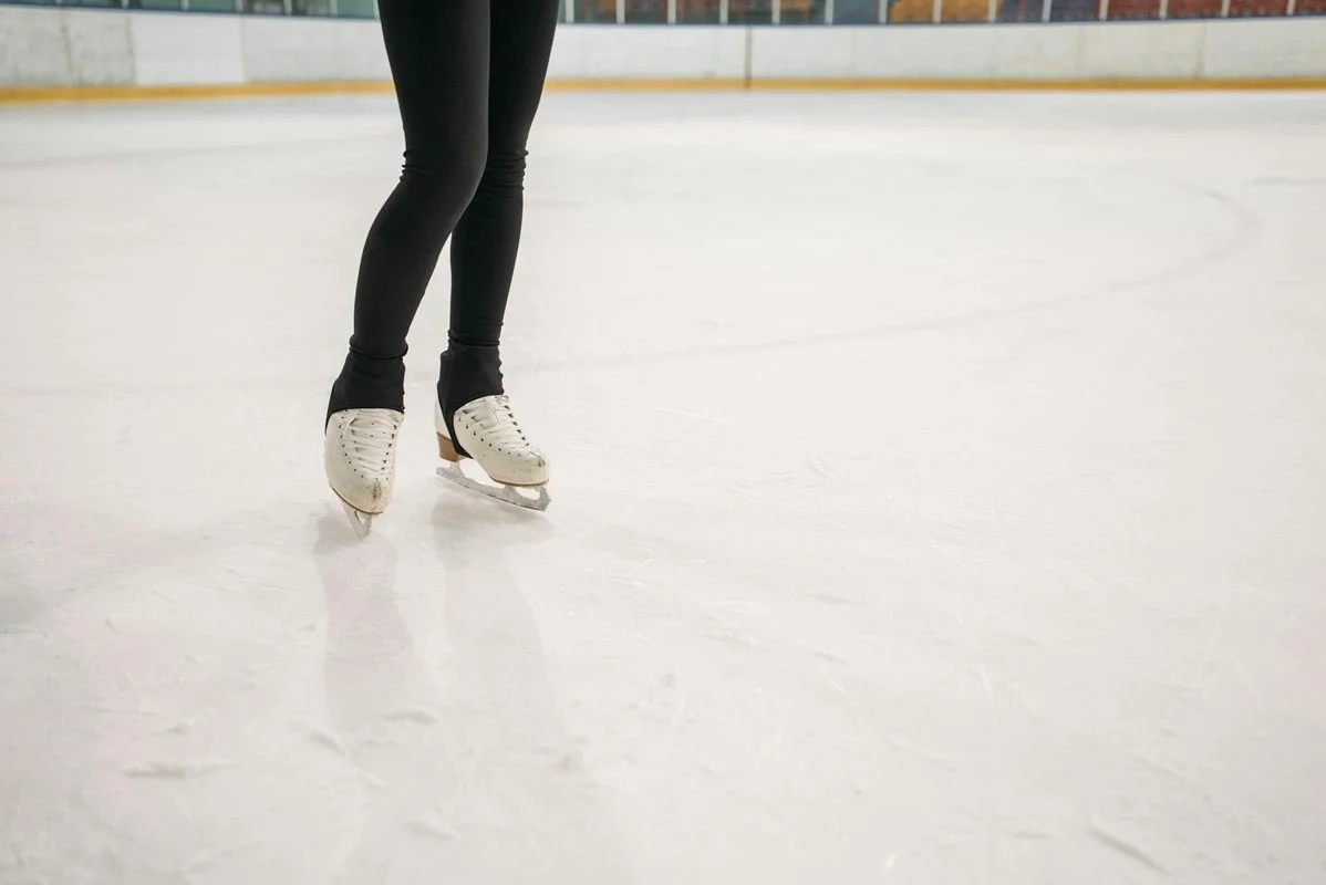 kaori sakamoto: Close-up of a figure skater's legs and skates gliding on an ice rink