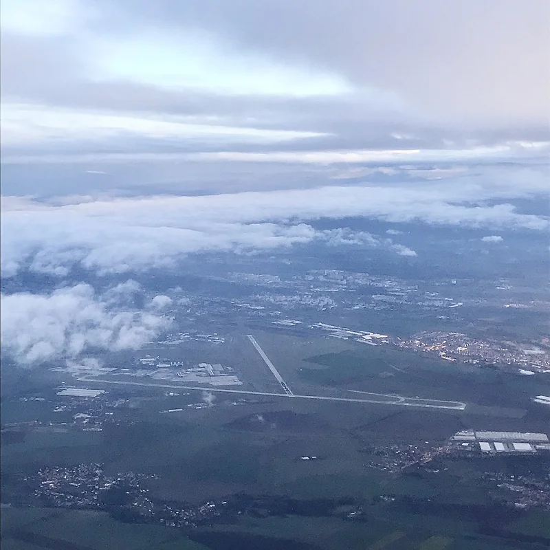 Letecký pohled na ranvej letiště Václava Havla Praha s městem v pozadí