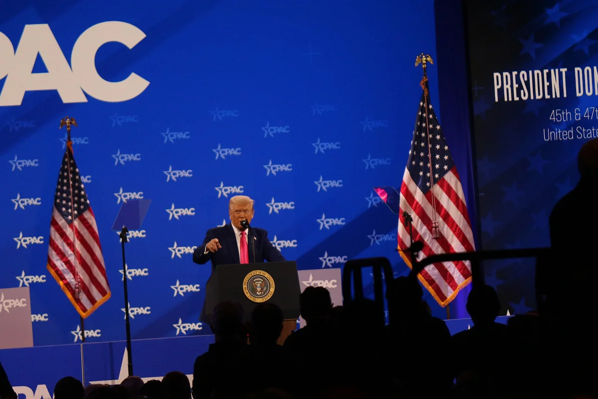 Donald Trump řeční na konferenci CPAC 2025 u prezidentského pultu