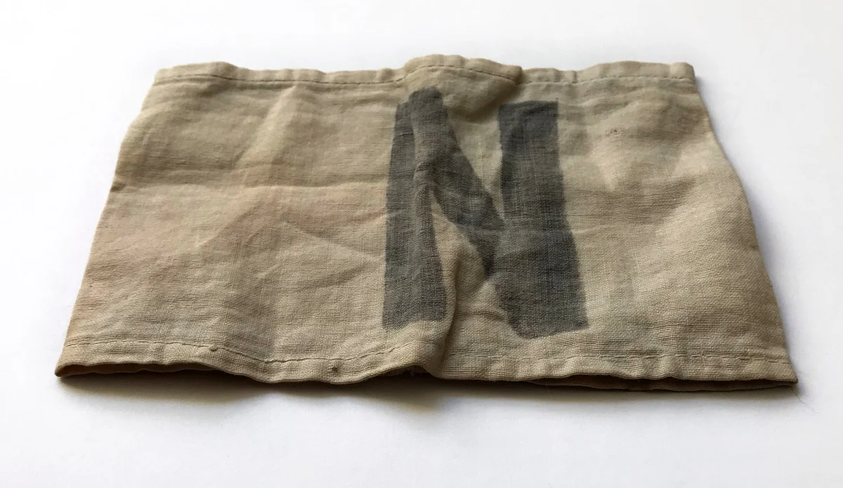 Armbinde s písmenem N, kterou museli nosit sudetští Němci před odsunem po vydání Benešových dekretů