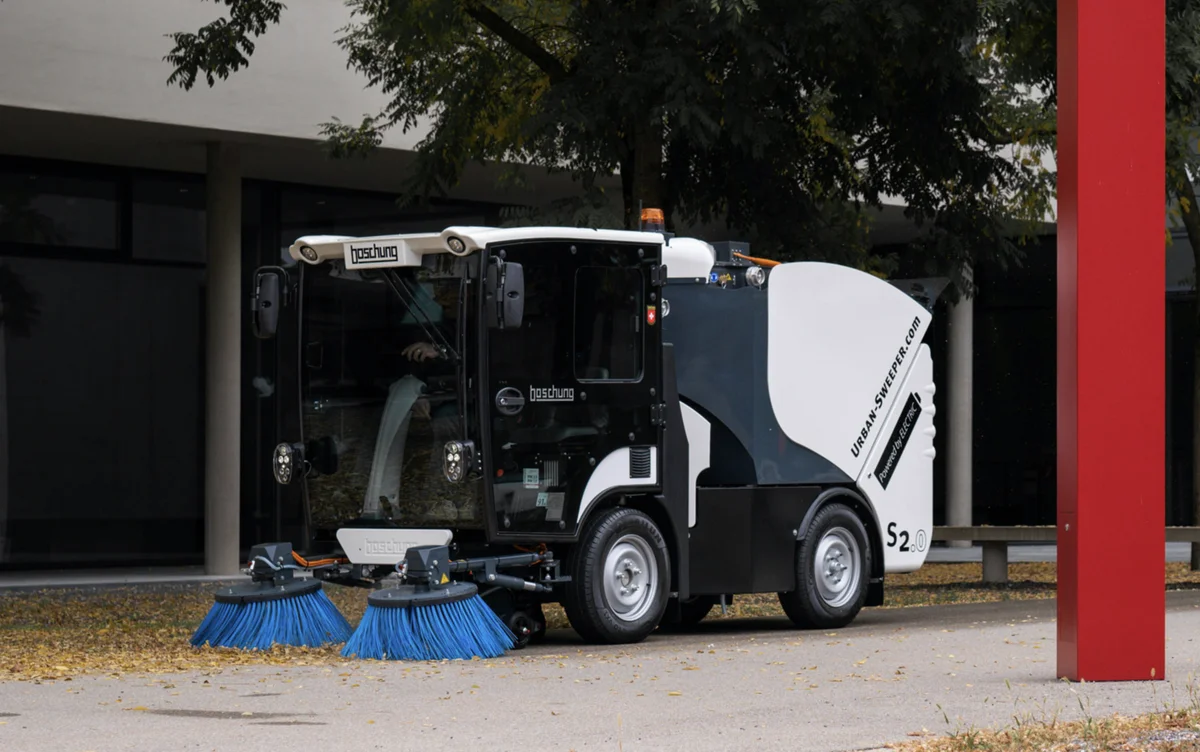 Moderní zametací vůz čistí městskou ulici během blokového čištění