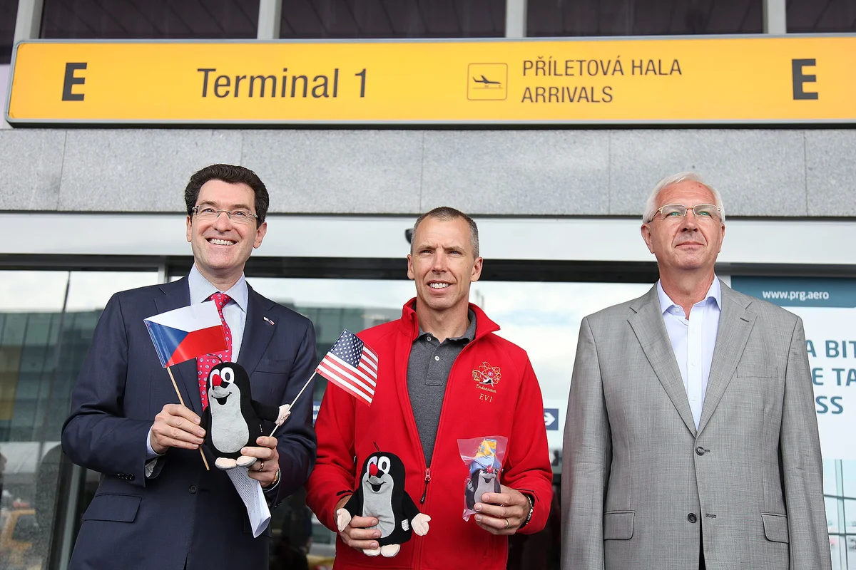 Norman Eisen, americký velvyslanec v Praze, s českou a americkou vlajkou na letišti
