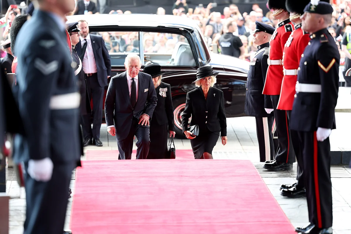 Král Karel III. přichází na státní ceremonii s čestnou stráží na červeném koberci