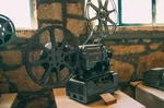 Starý filmový projektor s kotouči — symbol éry Petra Schulhoffa a českého filmu