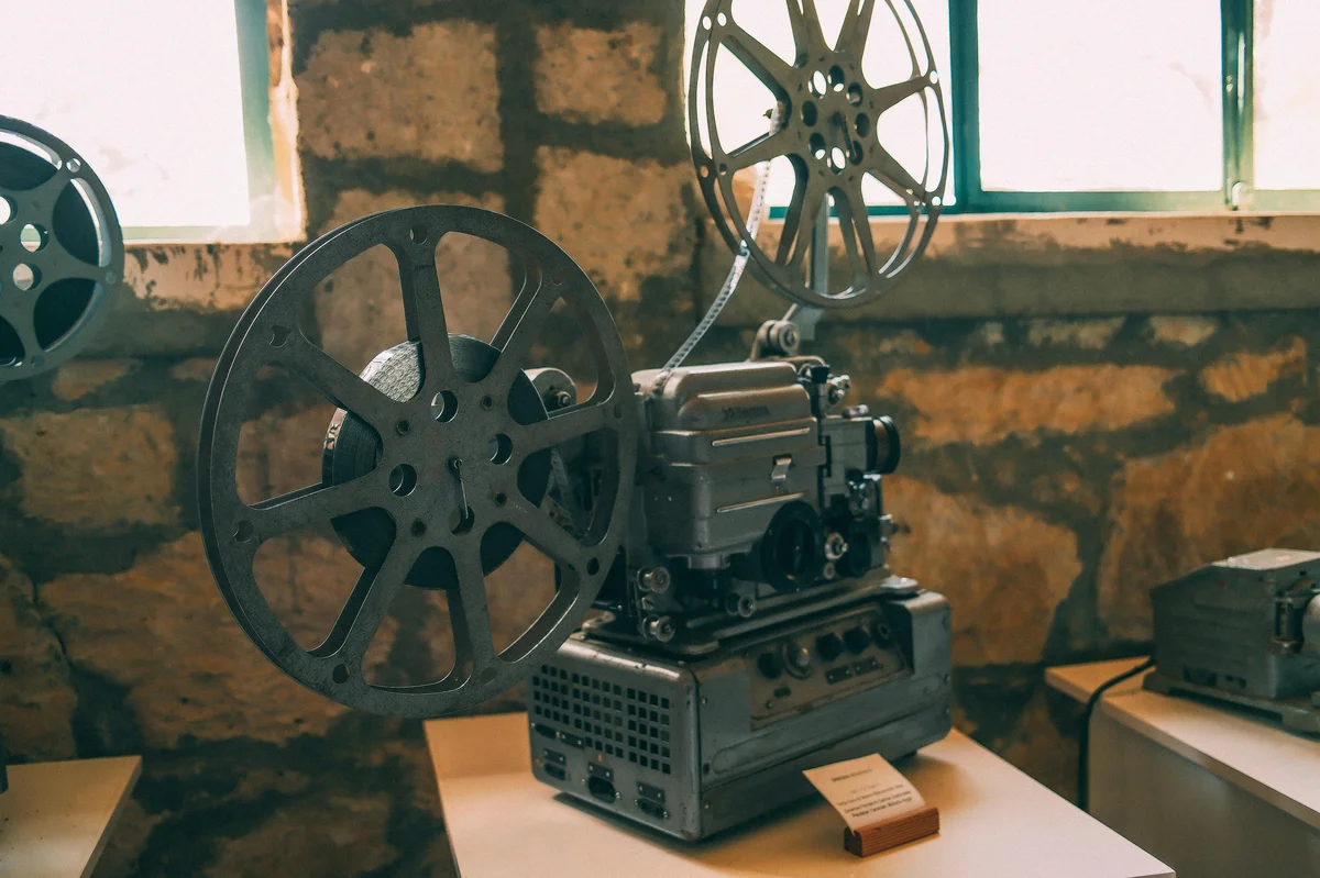 Starý filmový projektor s kotouči — symbol éry Petra Schulhoffa a českého filmu