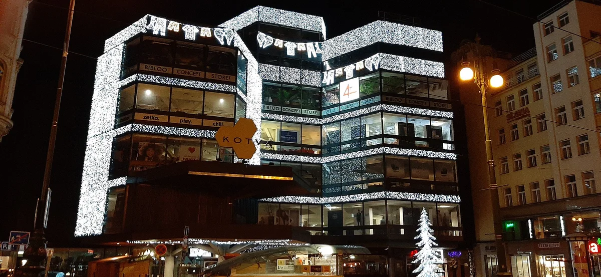 Obchodní dům Kotva Praha večer — rekonstrukce na luxusní obchodní centrum 2028
