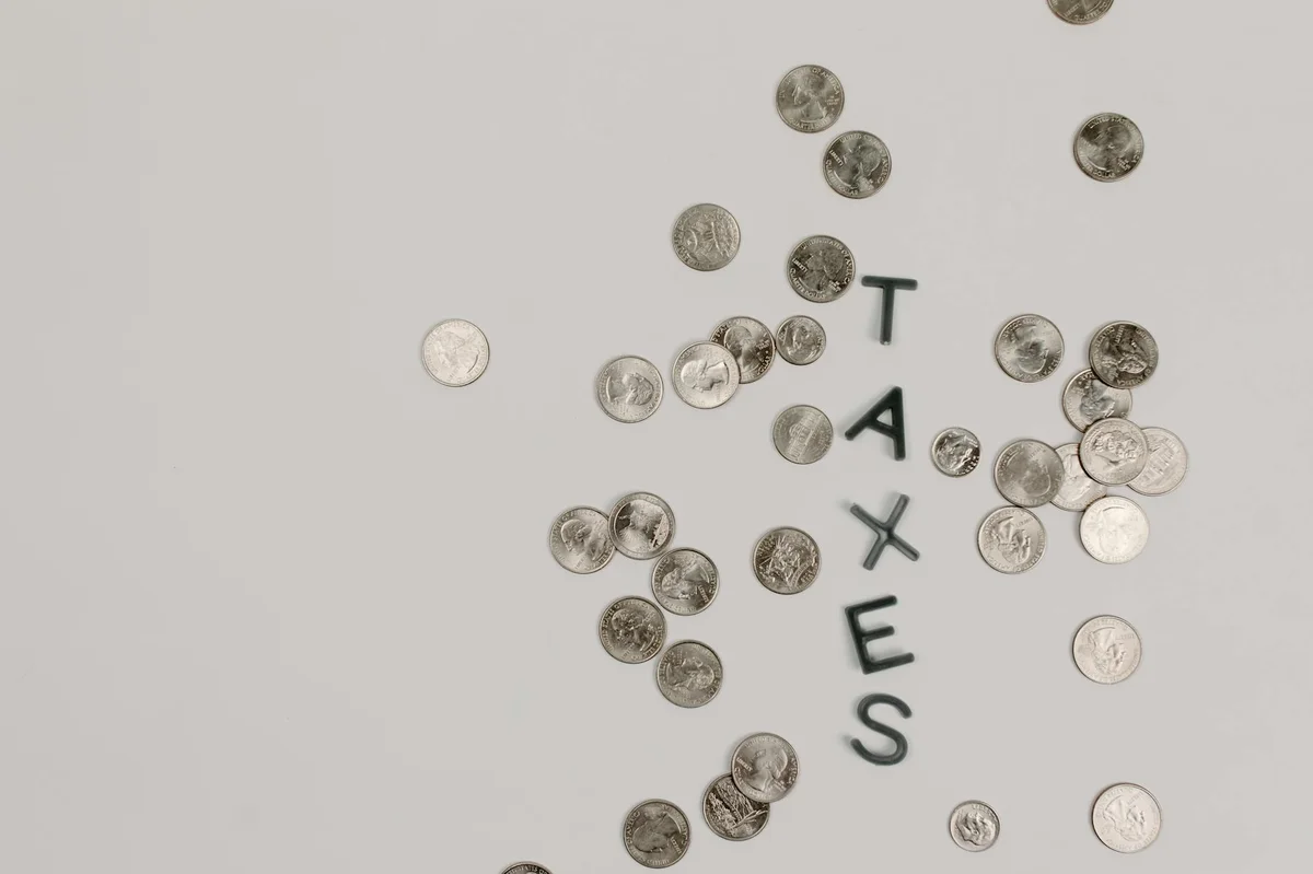 monety układające napis TAXES — podatek od wygranej Lotto w Polsce
