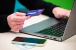 žena s kreditnou kartou pri laptope nakupuje online — ochrana pred podvodným e-shopom