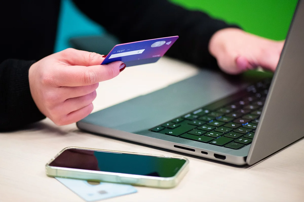 žena s kreditnou kartou pri laptope nakupuje online — ochrana pred podvodným e-shopom