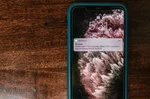 smartfon wyświetlający alert SMS o próbie oszustwa — vishing przez telefon