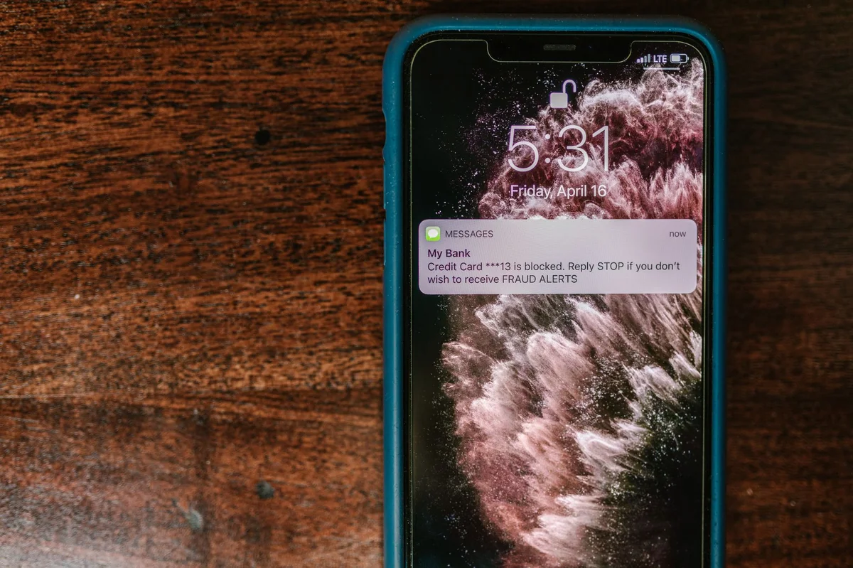 smartfon wyświetlający alert SMS o próbie oszustwa — vishing przez telefon