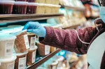 kobieta czyta etykietę produktu w sklepie — fałszowanie żywności jak rozpoznać
