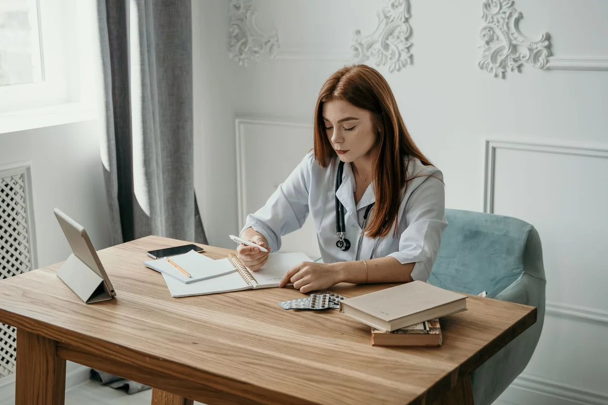 medic completând documente pentru concediu medical la birou