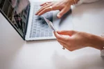kobieta trzyma kartę kredytową przy laptopie — prawa RODO zakupy online