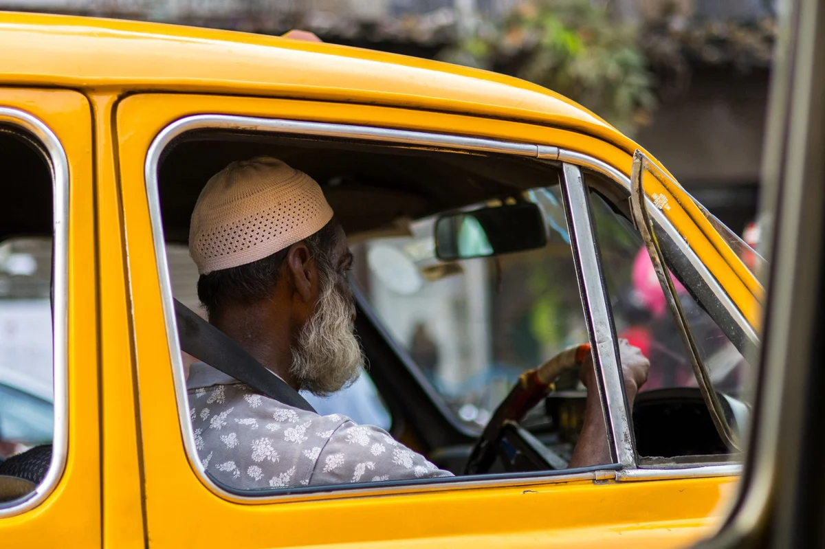 Starszy mężczyzna w żółtej taksówce — program taxi dla seniorów