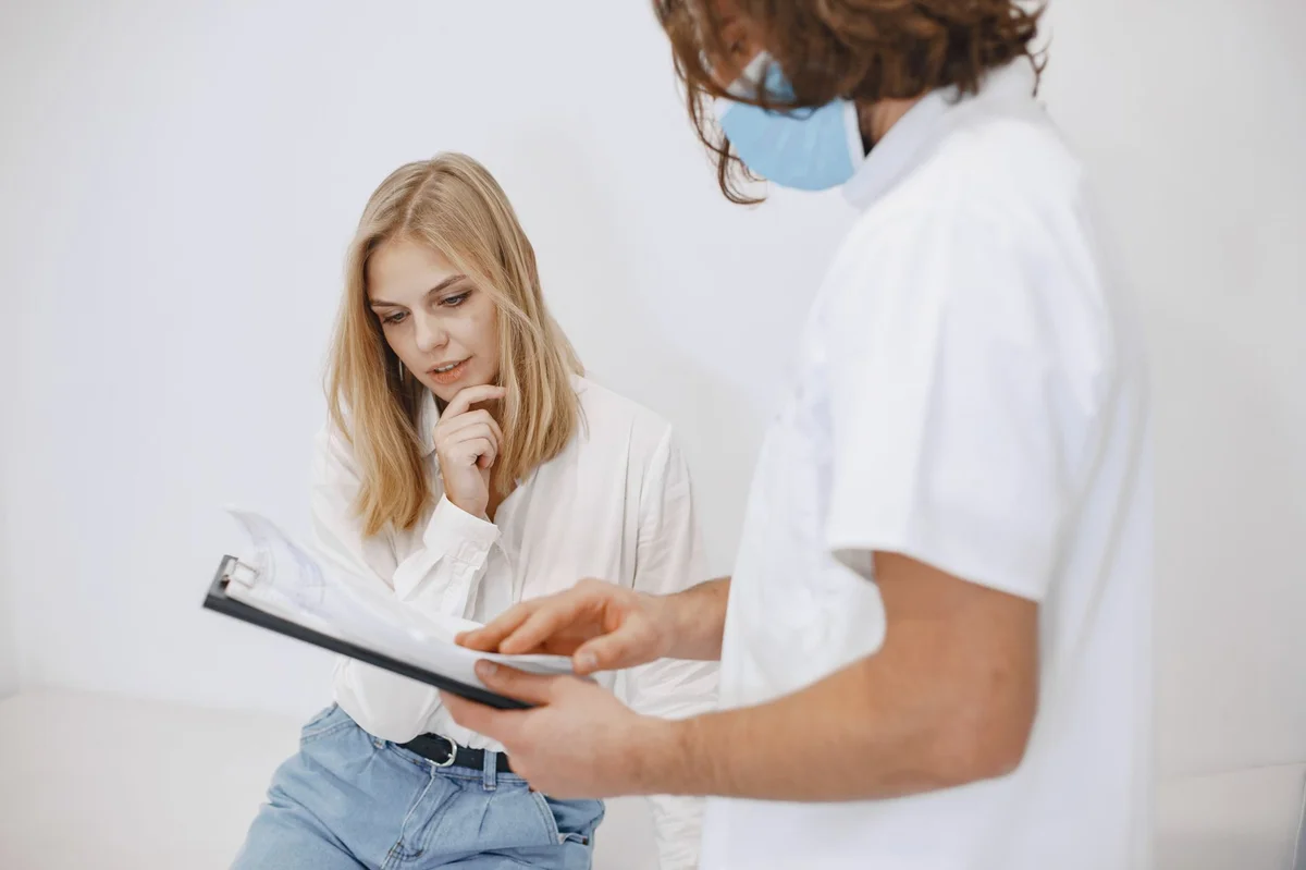 pacientă care analizează documente pentru concediu medical cod 14 cu medicul