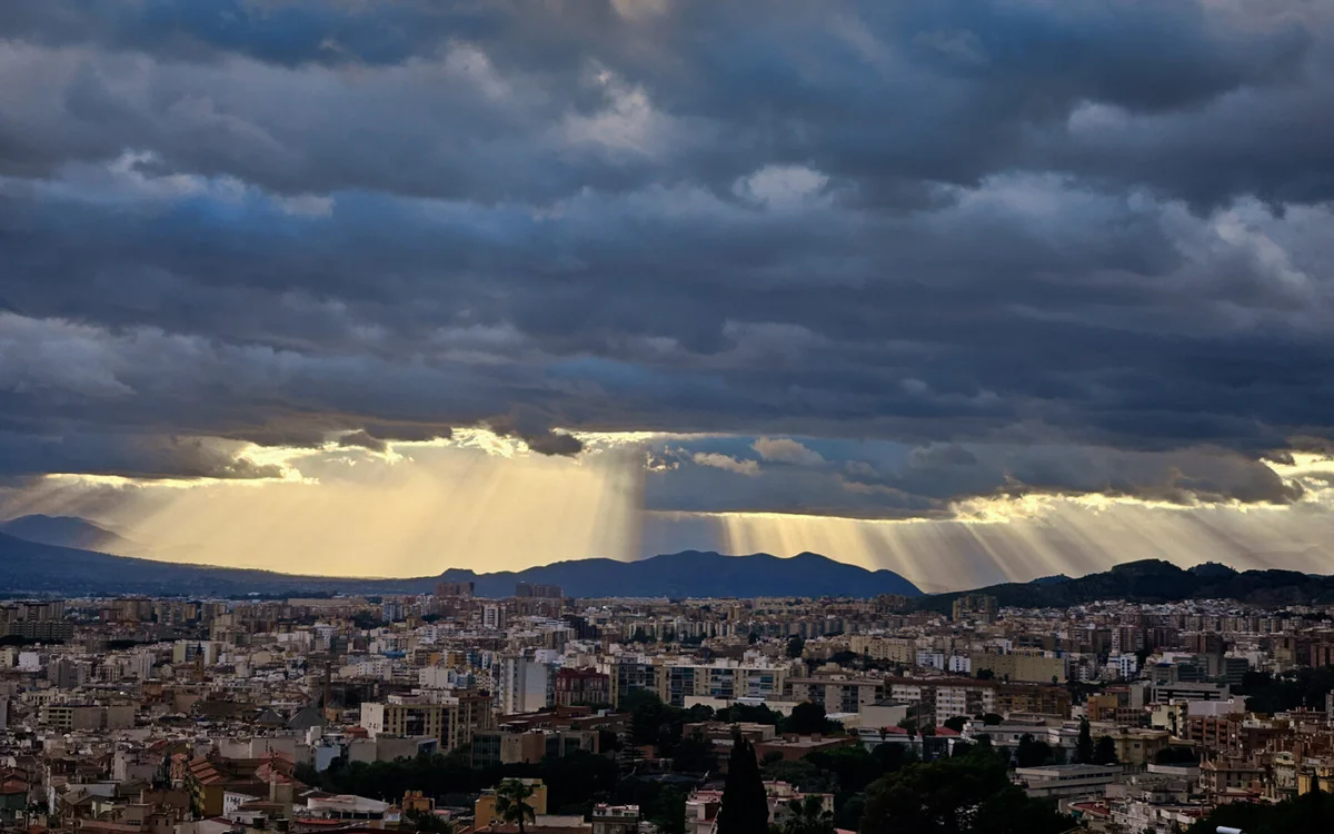 Nubes de tormenta sobre una ciudad española, seguros por daños de tormenta