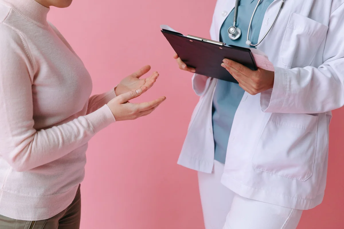 Doctor consulting patient with clipboard, symbolizing NFZ health insurance in Poland