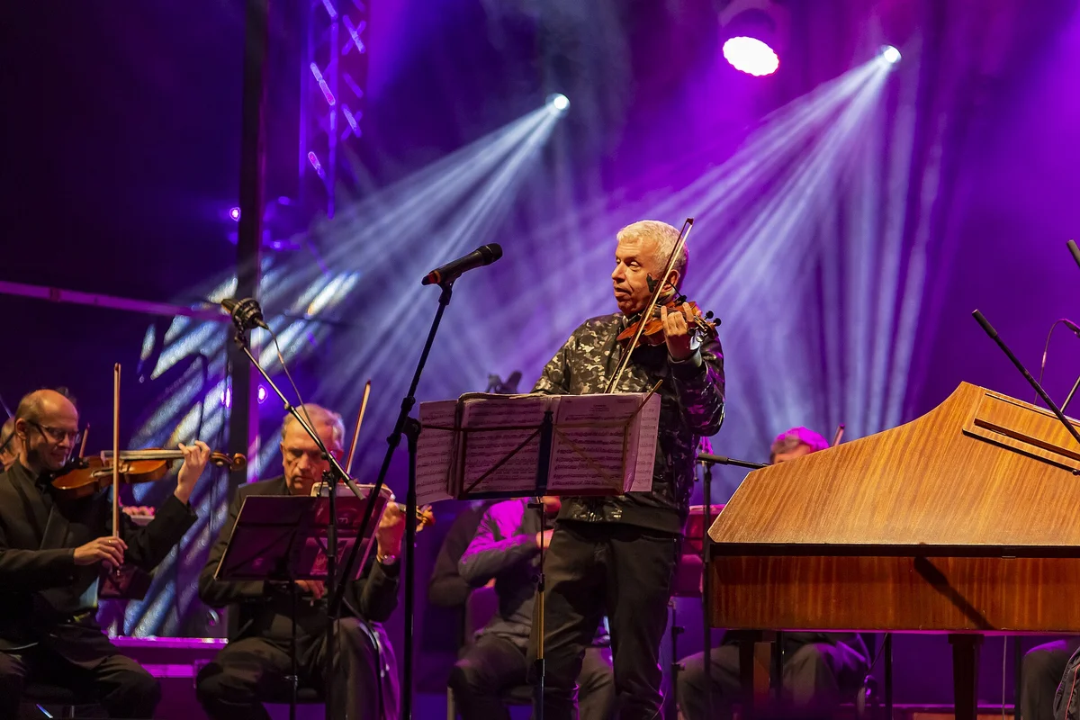 Jaroslav Svěcený hraje na housle s orchestrem při koncertě